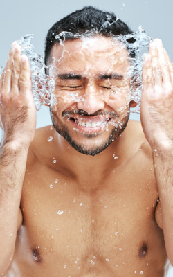 man splashing water on face