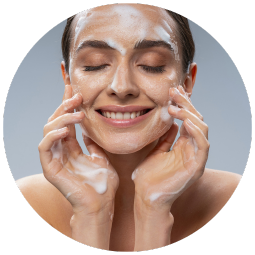 a woman washing her face with foam on her face