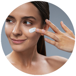 close up of a woman applying cream on her face