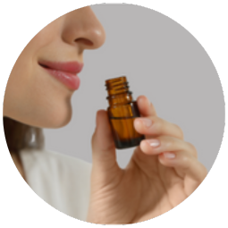 close-up of a woman holding a small bottle of essential oil